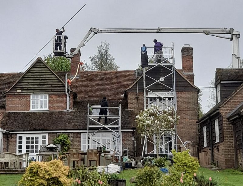 The Moss Cleaners using cherry picker and scaffolding to clean roof safely and professionally in Malmesbury, Wiltshire